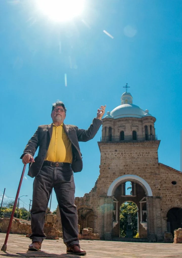 Fredy José Pinillos, creador del museo, de pie frente al Templo Histórico de Villa del Rosario bajo un cielo azul