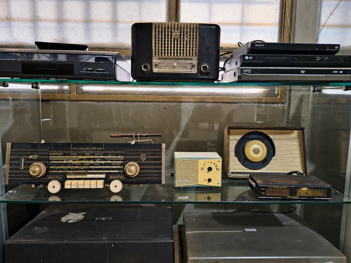 Vitrina con radios antiguos, un tocadiscos y reproductores apilados